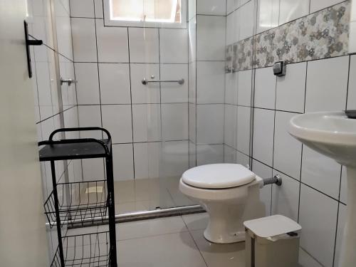 ein Badezimmer mit Toilette und Waschbecken in der Unterkunft Potiribu in Ijuí