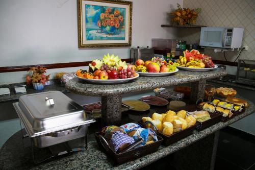 a kitchen counter filled with lots of different types of food at Bandeirantes Hotel in Cuiabá