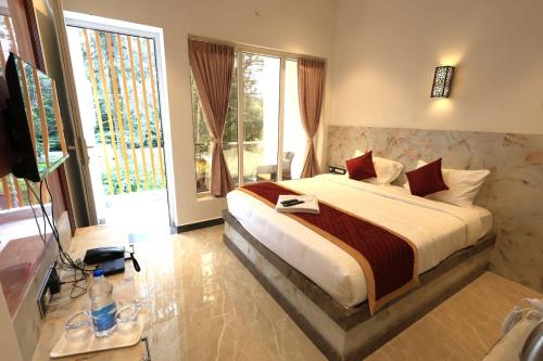 埃尔加德Ozone Hill Resorts的一间卧室，里面有一张床和一扇大窗户。