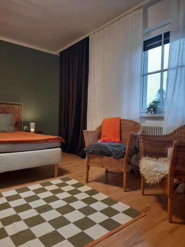 een slaapkamer met een bed, stoelen en een raam bij Im Stauberhaus in Kirchdorf an der Krems