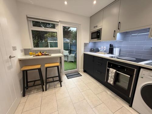 a kitchen with a counter and a sink and a stove at Little Spinney Lodge in Saint Leonards