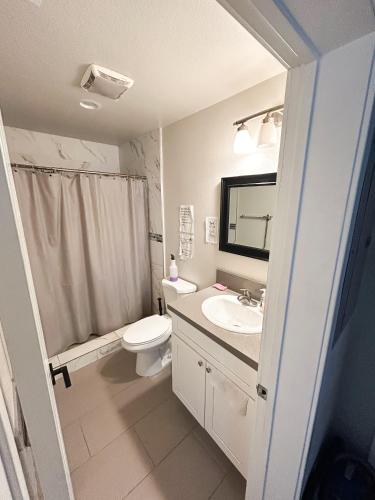 a white bathroom with a sink and a toilet at Vernon Vibes in Los Angeles