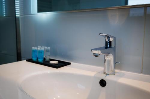 a bathroom sink with a faucet and a mirror at African Princess Beach Hotel in Serekunda