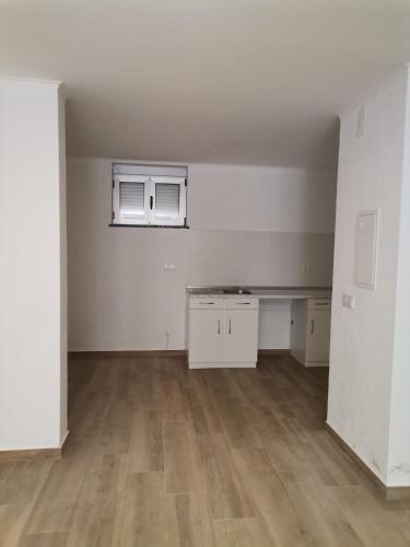 una stanza vuota con pareti bianche e pavimenti in legno di Casa Rainha Santa a Estremoz