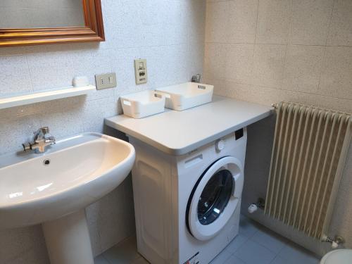 a bathroom with a washing machine and a sink at Casa del Capitano Hilton in Isolaccia