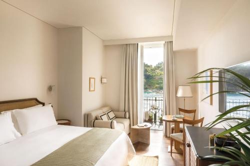 Una habitación de hotel con una cama, una silla y una ventana. en Splendido Mare, A Belmond Hotel, Portofino, en Portofino