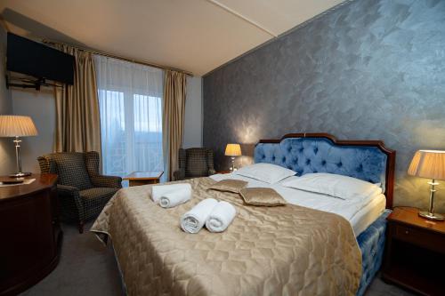 a bedroom with a large bed with towels on it at Hotel Belvedere in Predeal