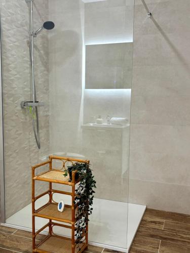 a bathroom with a shower with a wooden shelf and a sink at Chalet Lilas, spa privatif, 2p in Rochesson