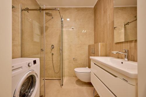 a bathroom with a shower and a toilet and a washing machine at Skyline Sunset in Becici