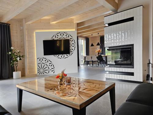 a living room with a table and a fireplace at Anielskie chaty - domki z widokiem na góry in Sablówka