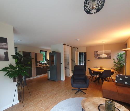 ein Wohnzimmer mit Sofa und Tisch in der Unterkunft 6 - Persoons Forest 217 Sauna Bungalow in Hernen