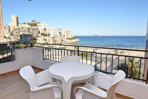 un tavolo bianco e sedie su un balcone con vista sull'oceano di Apartamentos Odysea By Apartamentos Valentia a Cala de Finestrat