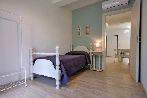 - une chambre avec un lit et un couloir avec une table dans l'établissement Le Magie di Gioba, à Chia