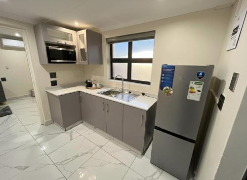 彼得马里茨堡The Corner Guesthouse的一个小厨房，里面有水槽和冰箱