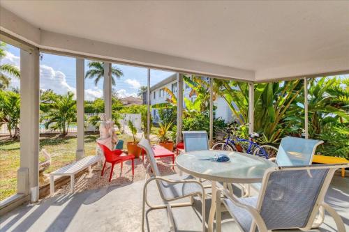 a porch with a table and chairs and a woman sitting at Southside Village Resort Apartments by Lucky Vacation Homes in Sarasota