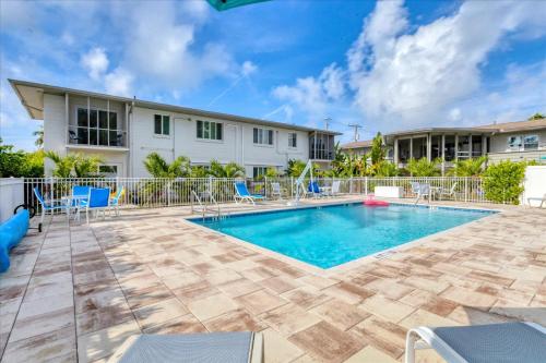 a swimming pool with chairs and a building at Southside Village Resort Apartments by Lucky Vacation Homes in Sarasota