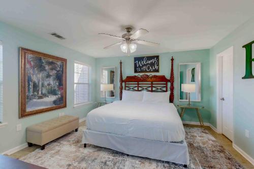 a bedroom with a white bed and a ceiling fan at Paradise in the Palms in Mexico Beach