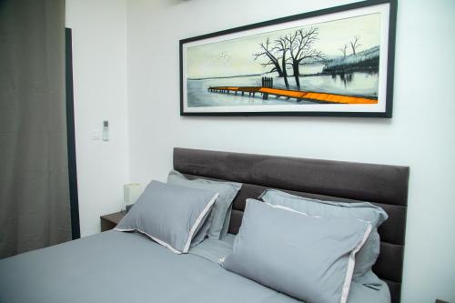 una camera da letto con un letto bianco con una foto sopra di Appartement Neuf meublé de Haut Standing a Dakar