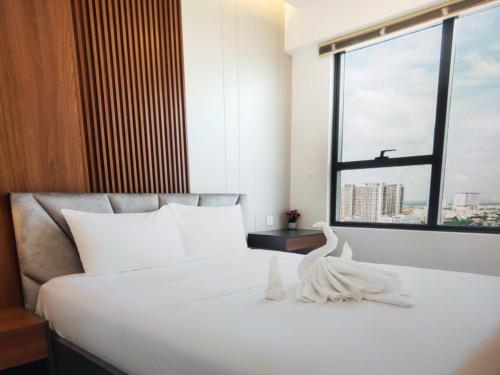 a bedroom with a large white bed with a window at The Levana Home Saigon in Ho Chi Minh City