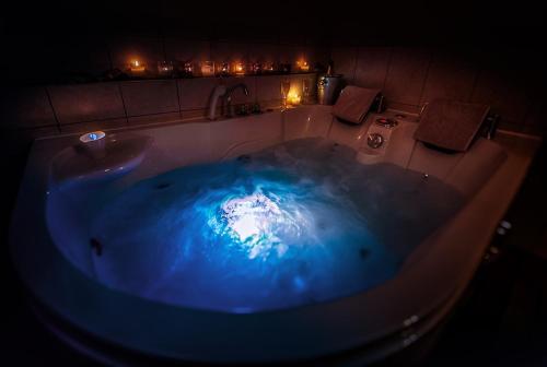 a large blue tub with a sink in a bathroom at Ferme Historique Jean De La Fontaine et ses chambres d'hôtes Hammam-Spa - 4 étoiles in Chierry