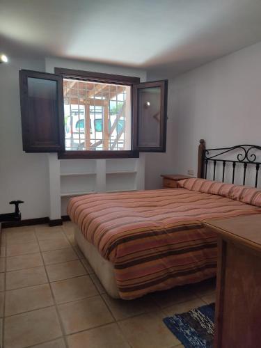 Un dormitorio con una cama grande y una ventana. en Casa Paulonia, en Las Negras