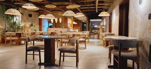 um restaurante com mesas e cadeiras em uma sala em Be Caju Hotel em Barra Grande