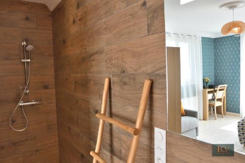 a bathroom with a wooden wall with a shower at Le Gîte de Mellonia - 7 chambres in Pouzauges