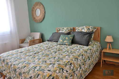 a bedroom with a bed with a comforter and a mirror at Le Gîte de Mellonia - 7 chambres in Pouzauges