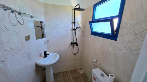 bagno con lavandino, finestra e servizi igienici di COCO JAMBO PARADISE Resort a Uroa