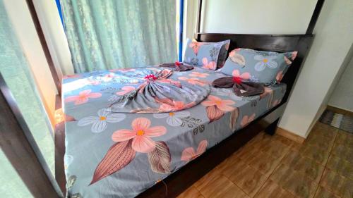 un letto con fiori rosa e viola di COCO JAMBO PARADISE Resort a Uroa