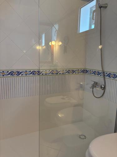 ein Badezimmer mit Dusche, Waschbecken und Toilette in der Unterkunft Villa Blanc in Sa Caleta