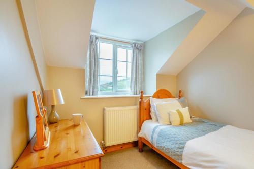 a bedroom with a bed and a table and a window at 2 Bed in Betws-y-Coed oc-84026 in Penmachno