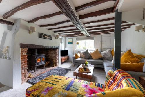 een woonkamer met een bank en een open haard bij 3 Bed in Letheringham oc-pclet in Kettleburgh