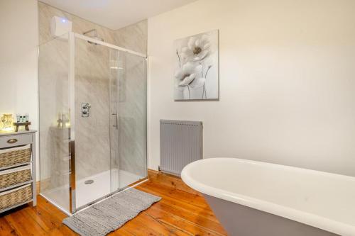 a white bathroom with a tub and a shower at 6 Bed in Blaencwm oc-t32688 in Blaencwm