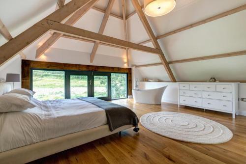 een slaapkamer met een bed en een badkamer met een bad bij 4 Bed in Drewsteignton oc-bc2408 in Drewsteignton