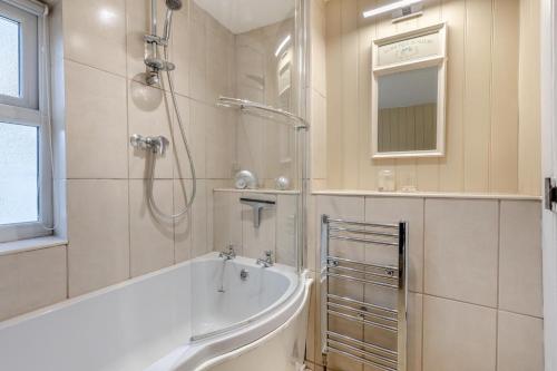 un bagno bianco con vasca e doccia di 3 Bed in Hindringham oc-861 a Hindringham