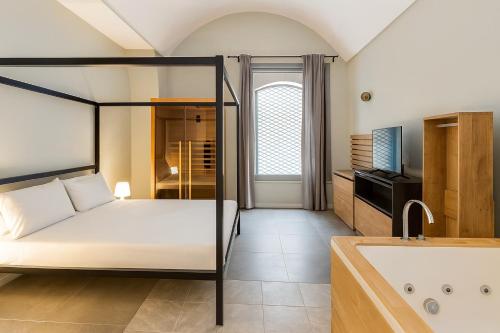 a bedroom with a bed and a tub and a sink at EUREKA APArtment in Catania