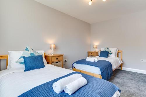 duas camas em um quarto com azul e branco em 2 Bed in Fowey oc-jackda em Fowey