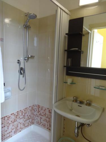 y baño con ducha y lavamanos. en Hotel Saturno en Chianciano Terme