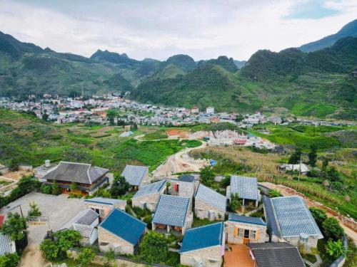 an aerial view of a village with mountains in the background at Thào Gia Homestay Mèo Vạc in Ha Giang