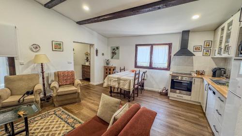 Una cocina y una sala de estar con mesa y sillas. en Ninho do Melro II - Turismo Rural Bragança, en Bragança