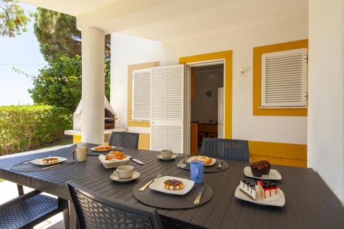 a black table with plates of food on it at B75 - Casa Delfim in Alfanzina Carvoeiro in Carvoeiro