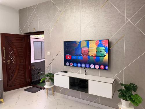 a living room with a flat screen tv on a wall at Sukruthi service apartment 3BHK in Mangalore