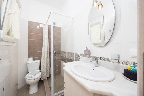 a bathroom with a sink and a toilet and a mirror at Villa Sequoia Yellow in Barbati