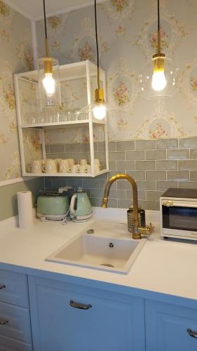a kitchen counter with a sink and lights above it at 2 SZ Ferienwohnung Hamburg zentral Parkplatz BoLA 24 in Hamburg