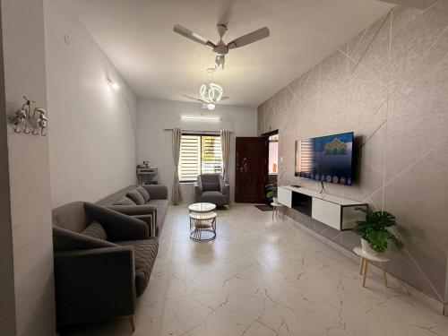 a living room with two couches and a tv at Sukruthi service apartment 3BHK in Mangalore