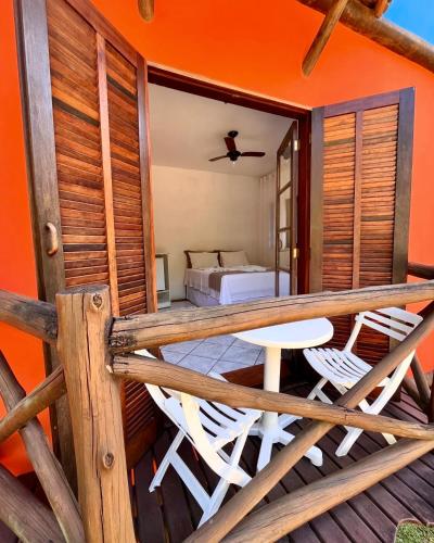 a balcony with two chairs and a bed in a room at Pousada Chalés Sinbad in Ilhabela
