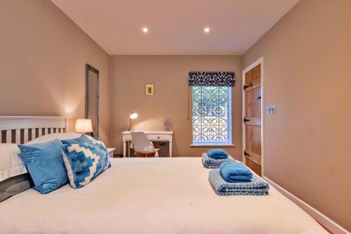 a bedroom with a bed with blue towels on it at Finest Retreats - The Asparagus Shed in Howell