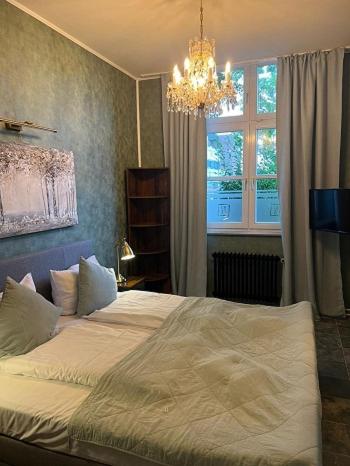 a bedroom with a bed with a chandelier and a window at Große Fewo mit 2 SZ & 2 Bäder mit Parkplatz BoLA 22 in Hamburg