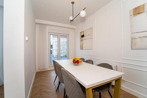 a dining room with a white table and chairs at Villa Oasis Aria in Mostar